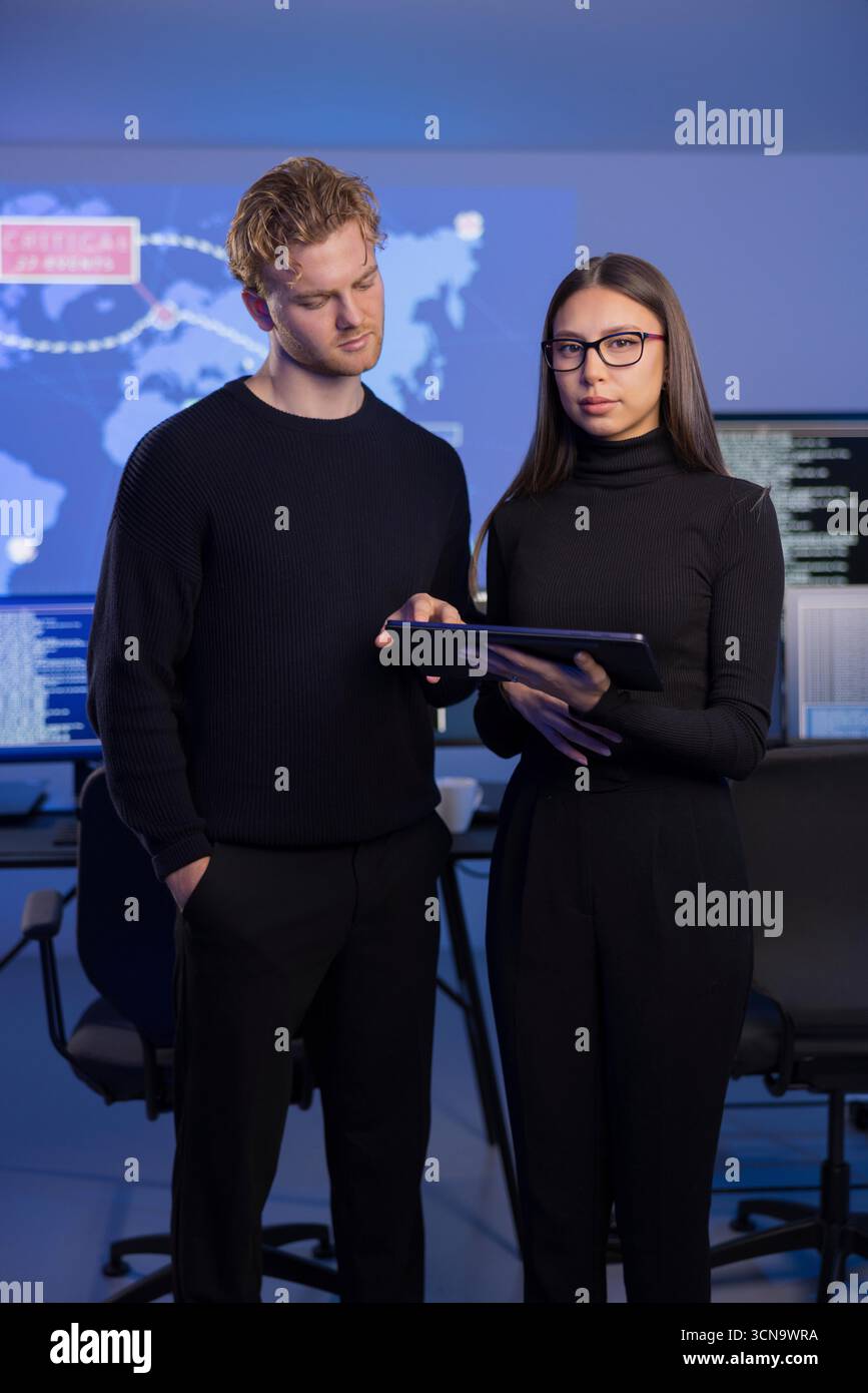 Analisti professionisti indagano sugli incidenti di sicurezza informatica in un ambiente avanzato di sala di controllo Foto Stock