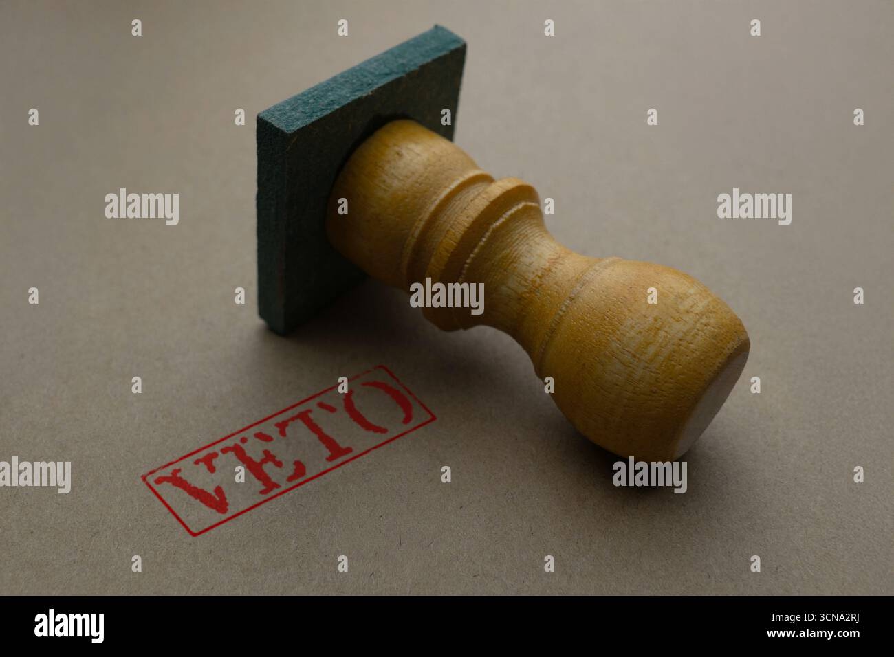 Primo piano di un timbro in legno con la parola "VETO" stampigliata con inchiostro rosso su una superficie marrone. Concetto di rifiuto, autorità o potere decisionale. Foto Stock