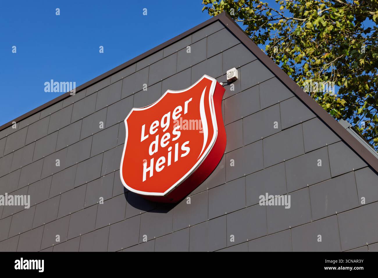L'iconico logo rosso dello scudo del Leger des Heils (Esercito della salvezza) sul lato di un edificio, simboleggia la carità, la speranza e il servizio della comunità. Utrech Foto Stock