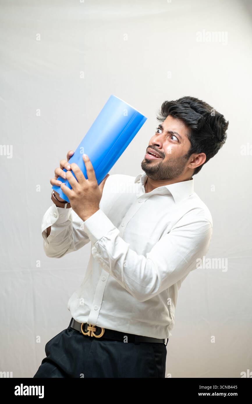 Un giovane che tiene scherzosamente un legante blu, guardando di lato. Foto Stock