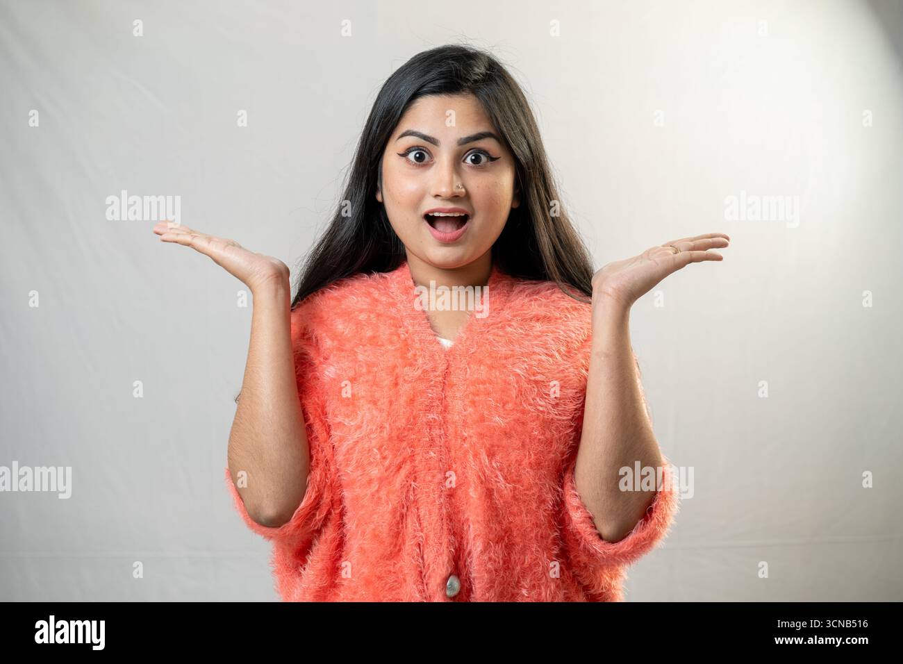Una giovane donna con un'espressione scioccata e le mani alzate. Foto Stock Una giovane donna con un'espressione scioccata e le mani alzate. Foto Stock