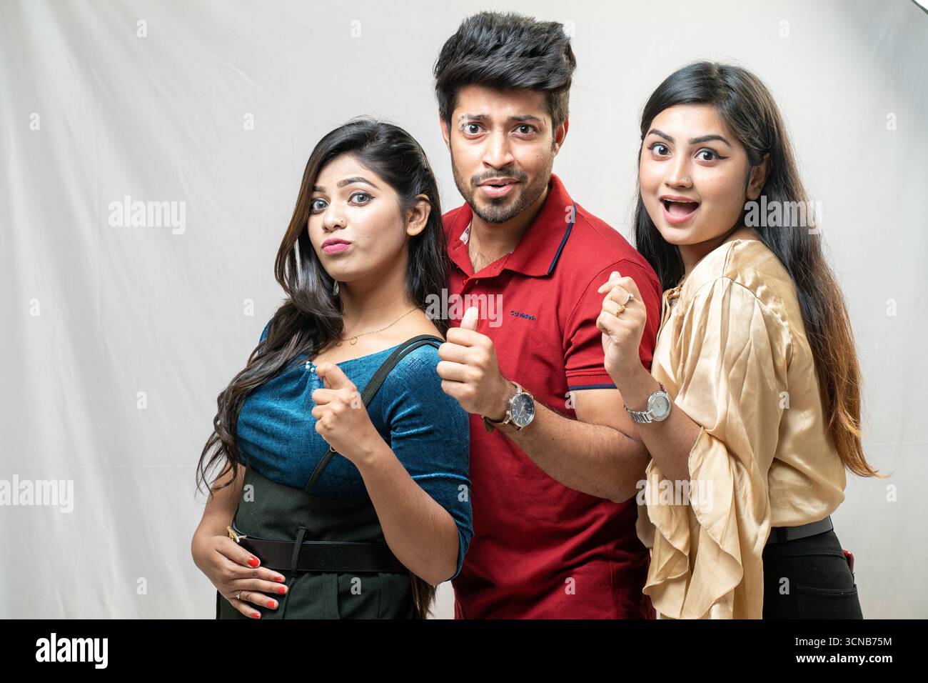 Tre giovani amici che fanno gesti con il pollice Foto Stock