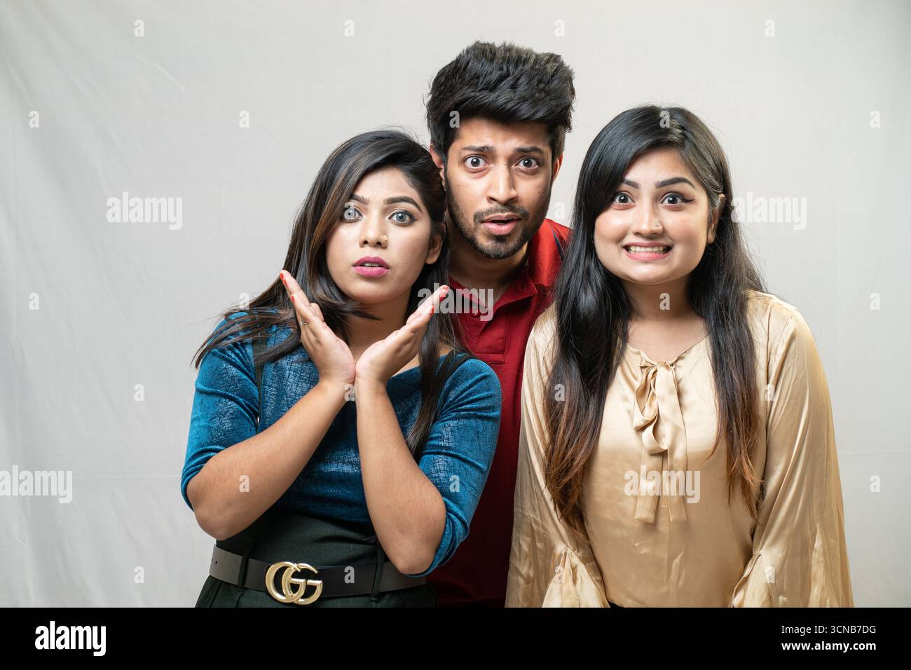 Tre giovani amici con espressioni sorprese e sconcertate Foto Stock