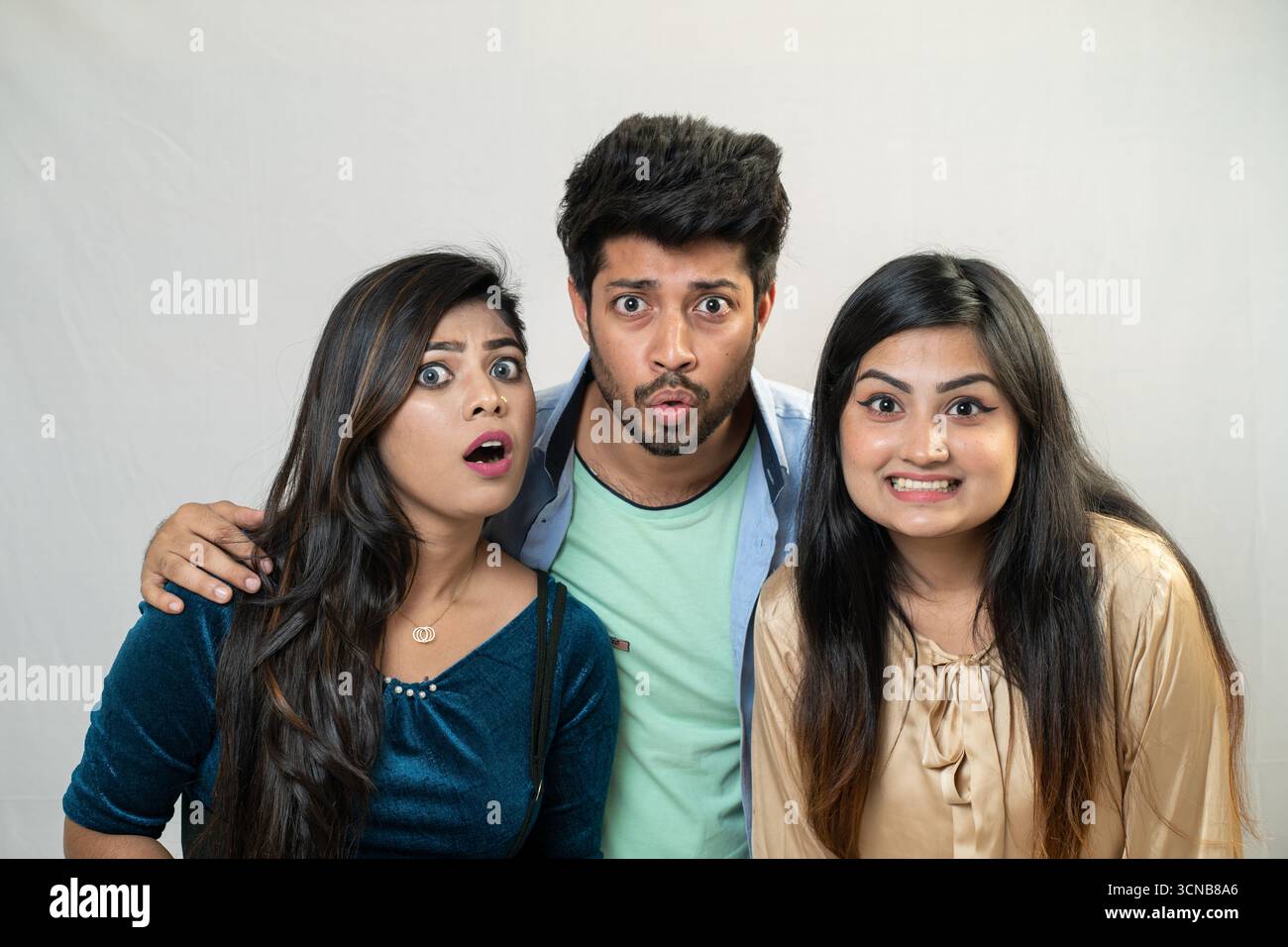 Tre amici con espressioni sorprese e scioccate. Foto Stock