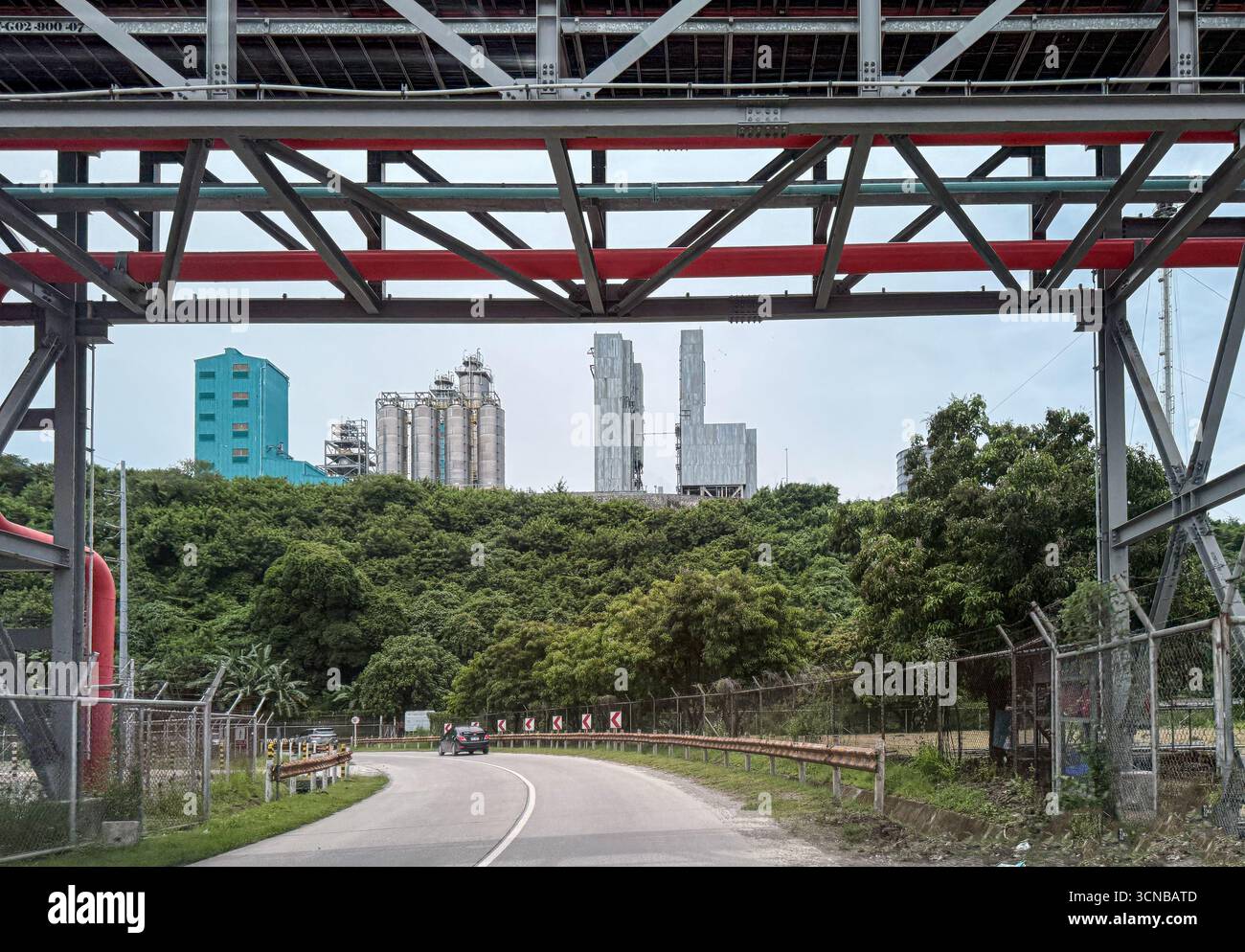 Batangas (distretto di Simlong), Filippine. 20 settembre 2025. Il complesso petrolchimico del JG Summit, il più grande produttore e operatore di poliolefine delle Filippine dell'unico cracker a vapore del paese, si affaccia sulla strada costiera attraversata da ponti di cremagliere con condutture industriali. Unità di cracking e polimeri di nafta (polietilene e polipropilene), colonne di distillazione, silos in acciaio inox e edifici di processo sorgono dietro la vegetazione collinare. L'espansione del sito è stata inaugurata nel 2024 da Pres. Marcos Jr. Crediti: Kevin Izorce/Alamy Live News Foto Stock