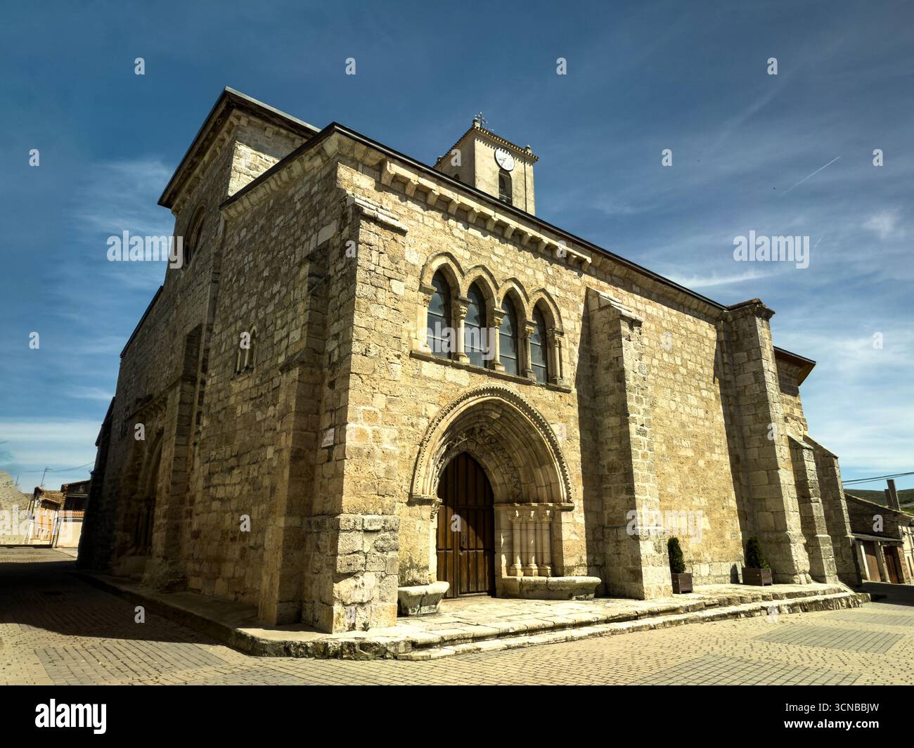Storica chiesa romanica con ingresso ad arco e torre dell'orologio nel paese di Vertavillo Foto Stock