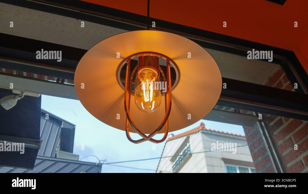 Calda luce a sospensione edison d'epoca in un ambiente accogliente Foto Stock