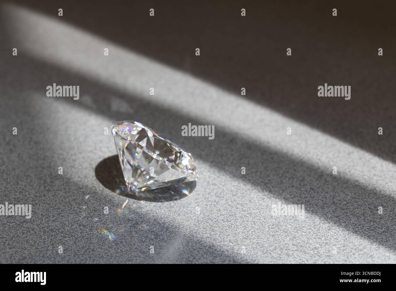 Gemma Diamond Luxury su pietra grigia con luce solare Foto Stock