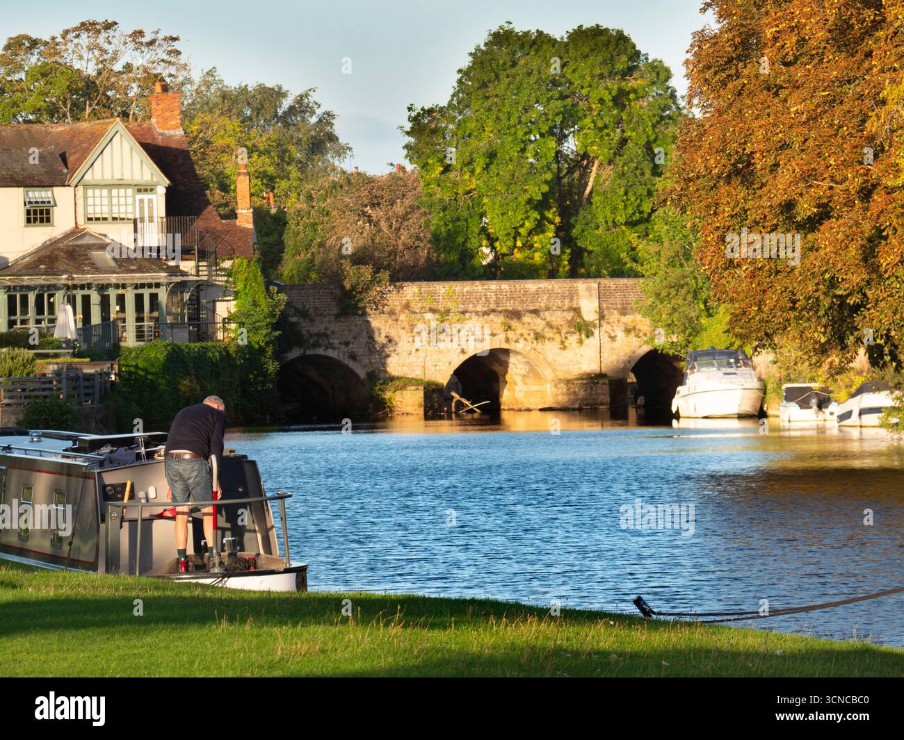 Casa galleggiante ormeggiata sul Tamigi ad Abingdon. Una bella vista del Tamigi ad Abingdon, in tarda mattinata d'estate. Siamo sulla riva sud del fiume, guardando da un'altra parte del ponte medievale di Abingdon. Foto Stock