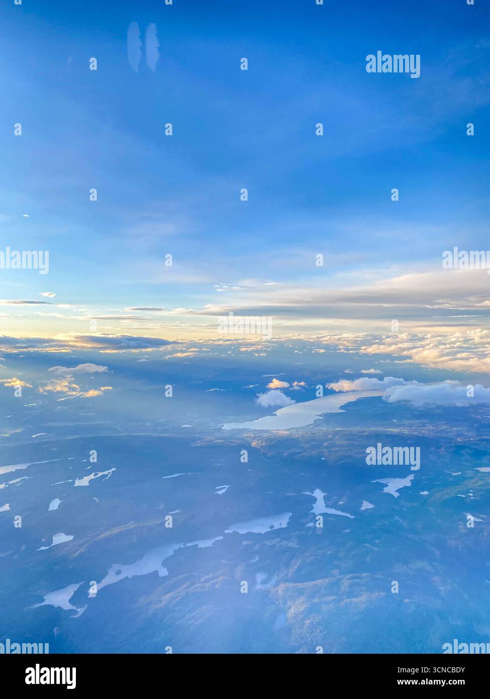 Vista alta da una finestra di oblò per i passeggeri di diversi fiordi nel Parco Nazionale di Hallingsskarvet mentre il sole d'autunno tramonta sul nord-ovest di Oslo, capi - Immagine stock catturata con smartphone