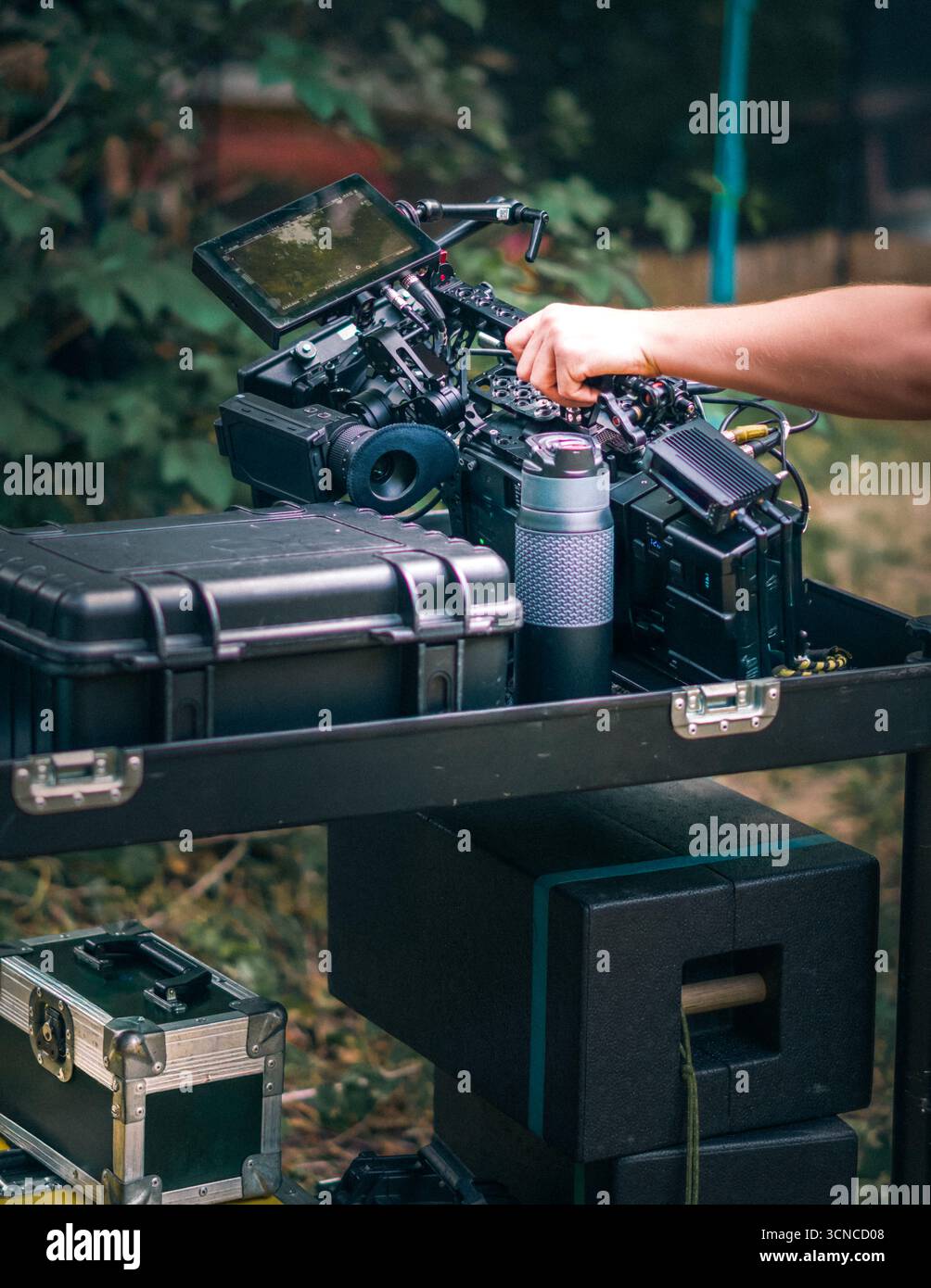 Attrezzatura professionale per telecamere a pellicola allestita all'aperto con attrezzatura di fascia alta, custodie protettive e accessori tecnici disposti su carrello. Foto Stock