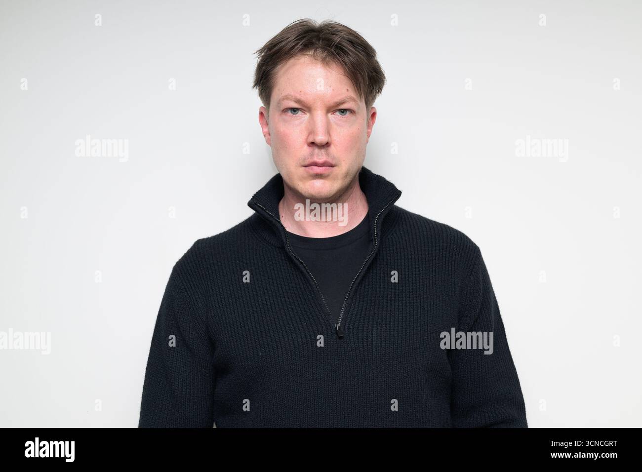 Uomo medio adulto scandinavo in un ritratto di maglione nero su sfondo bianco in studio Foto Stock