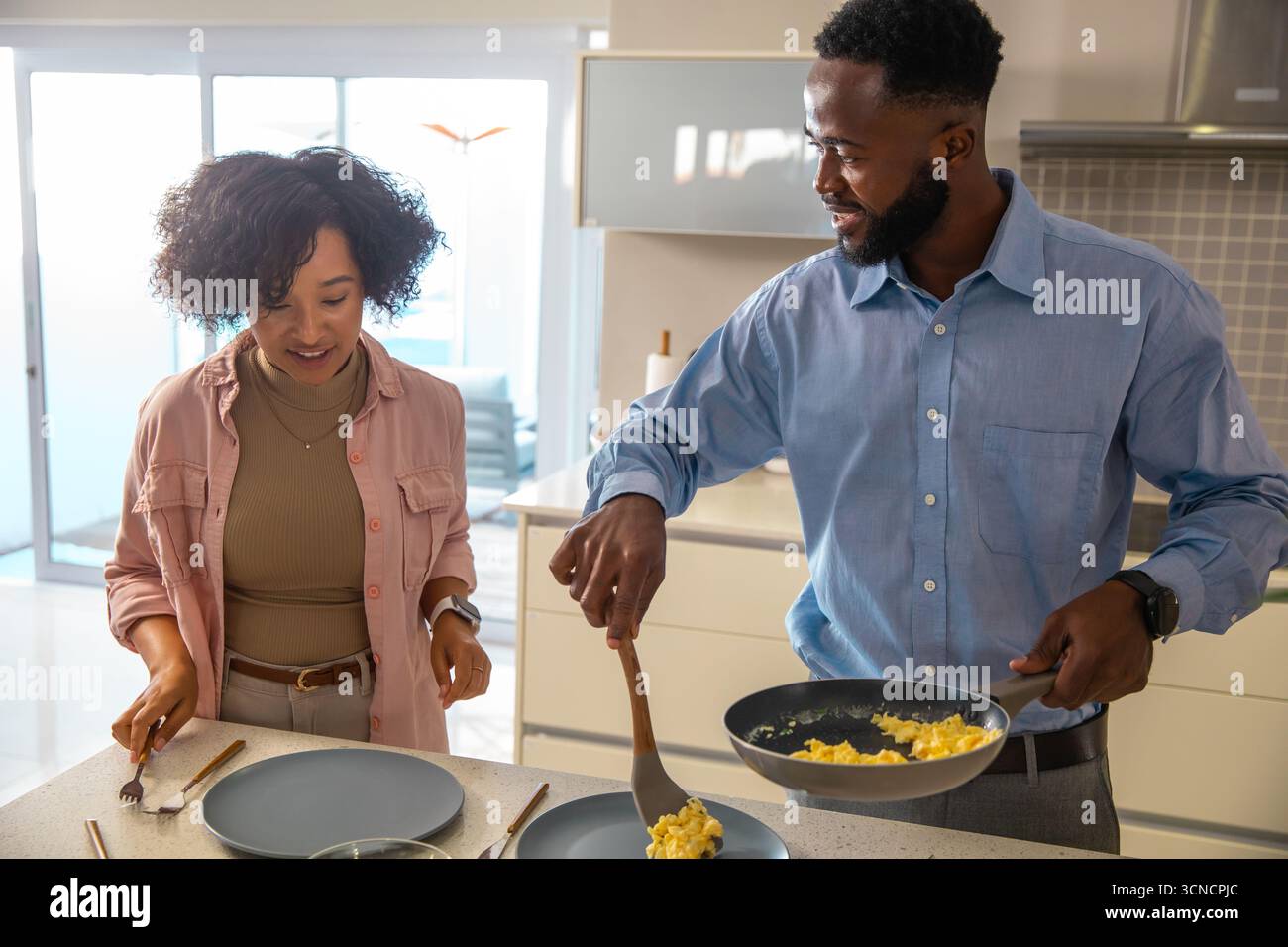 Diverse coppie che tengono la padella e la spatola, cucinano uova strapazzate sul ripiano in cucina Foto Stock