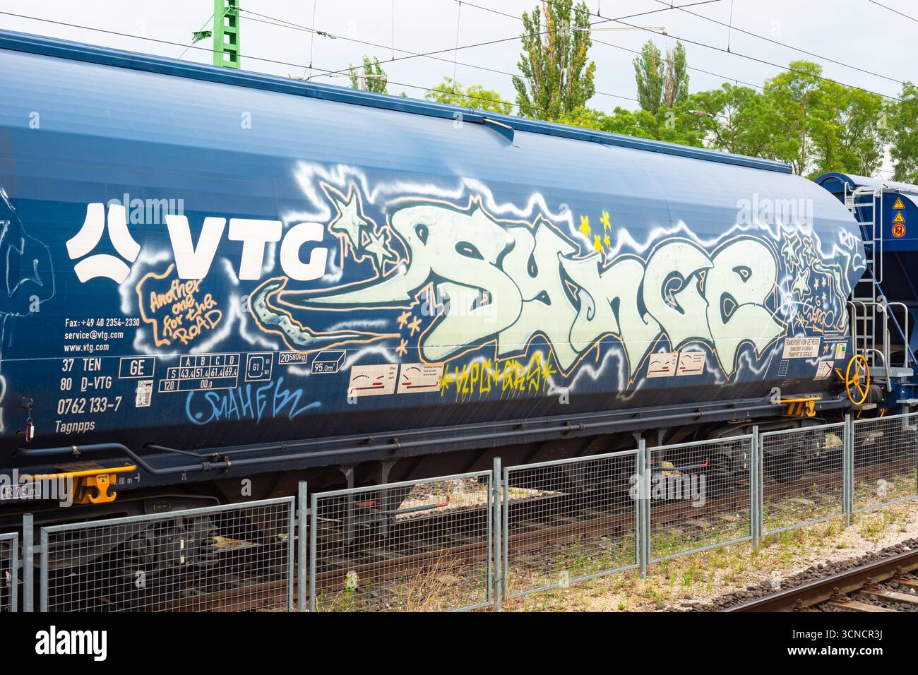 Carro cisterna blu vivace rivestito di audaci graffiti Foto Stock