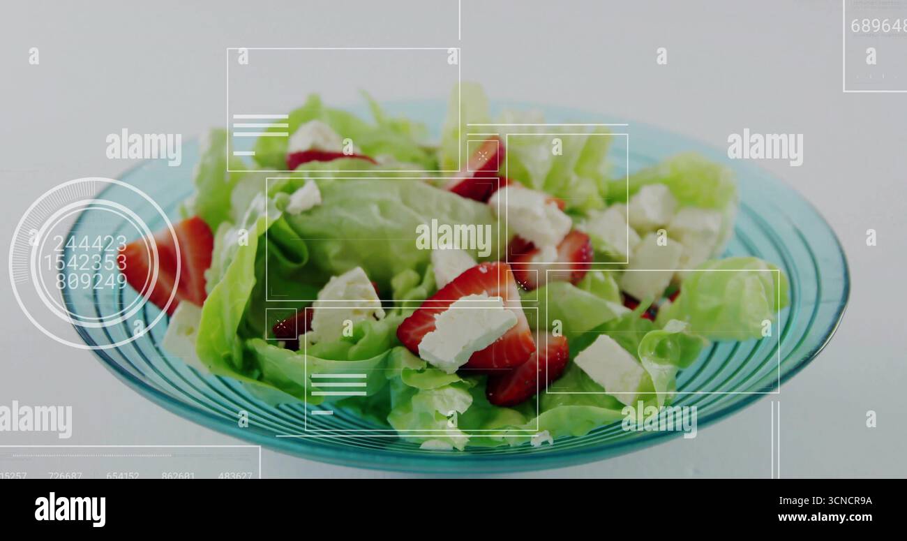 Ciotola turchese in cucina, con lattuga, fragole a fette, cubetti di formaggio e sovrapposizioni UI Foto Stock