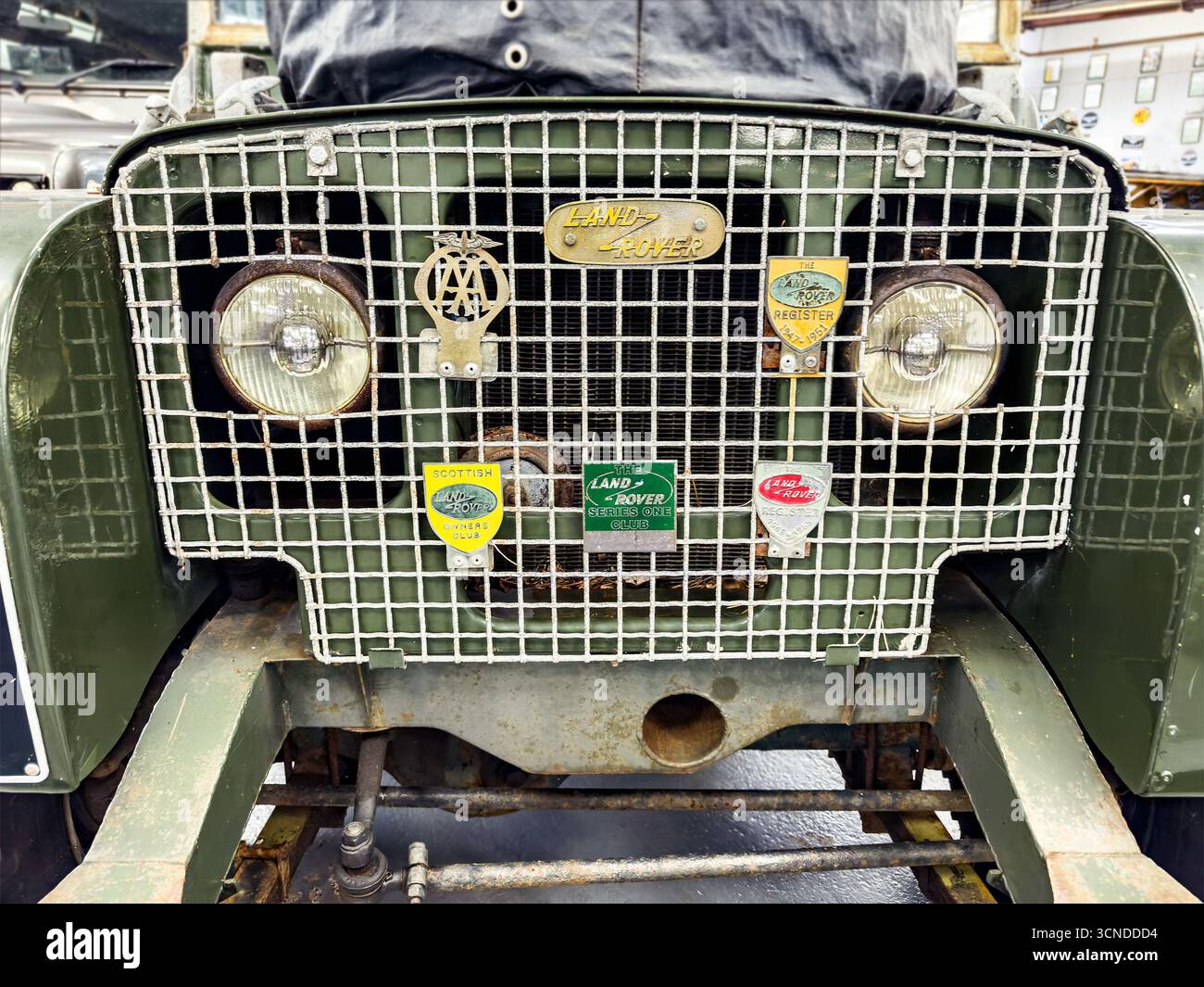 Primo piano di una griglia anteriore Land Rover vintage con logo in metallo AA e un aspetto robusto, emblematico del design automobilistico classico - Immagine stock catturata con smartphone