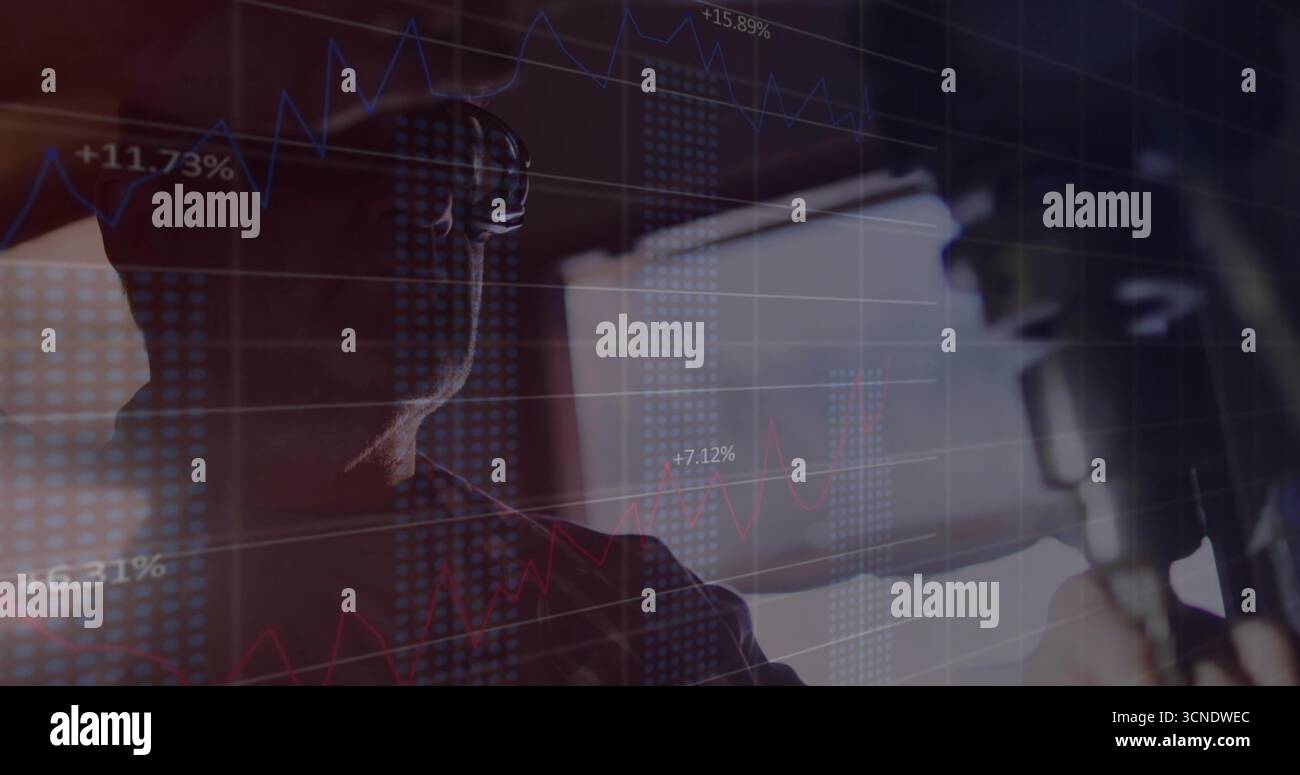 Registrazione host indossando cuffie in studio, con microfono, monitor per computer e dati di mercato Foto Stock