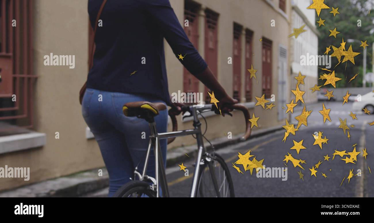 Donna con top navy che guida una bicicletta argentata in strade strette, con borsa a tracolla e stelle dorate Foto Stock