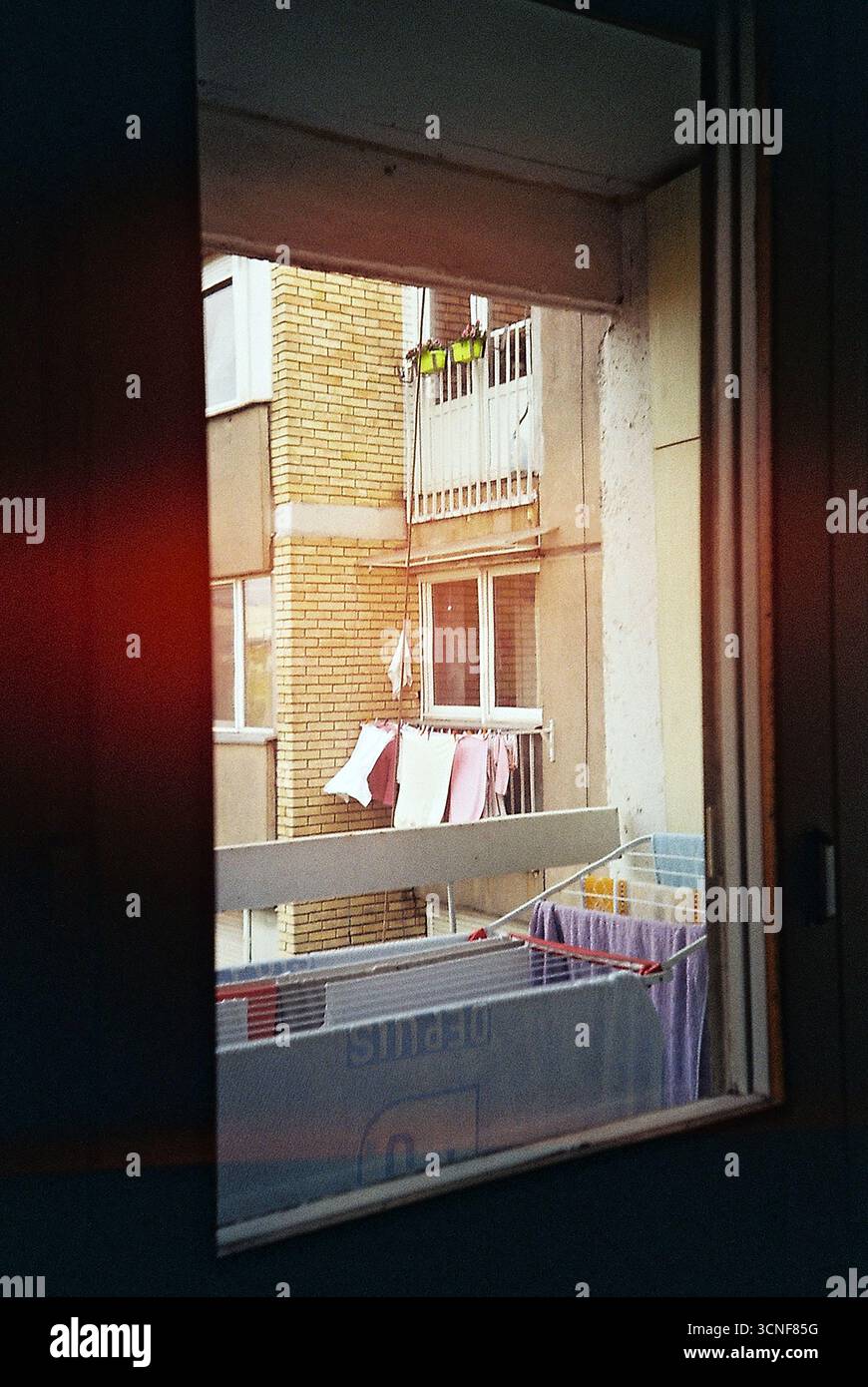 foto nalog di un edificio brutalista visto dalla finestra di un appartamento. Una vista tranquilla dell'architettura socialista e della vita quotidiana urbana. Foto Stock