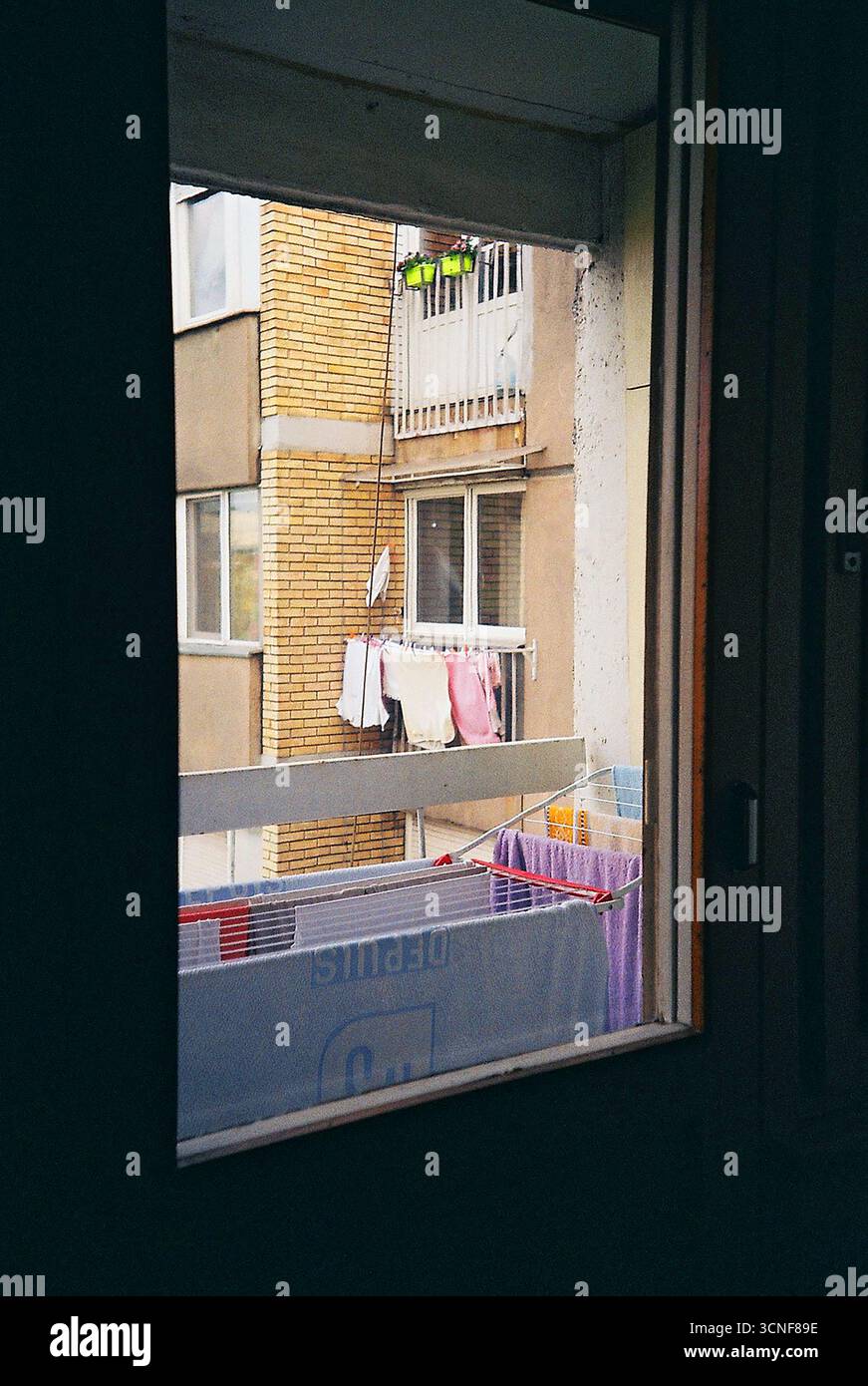 foto nalog di un edificio brutalista visto dalla finestra di un appartamento. Una vista tranquilla dell'architettura socialista e della vita quotidiana urbana. Foto Stock