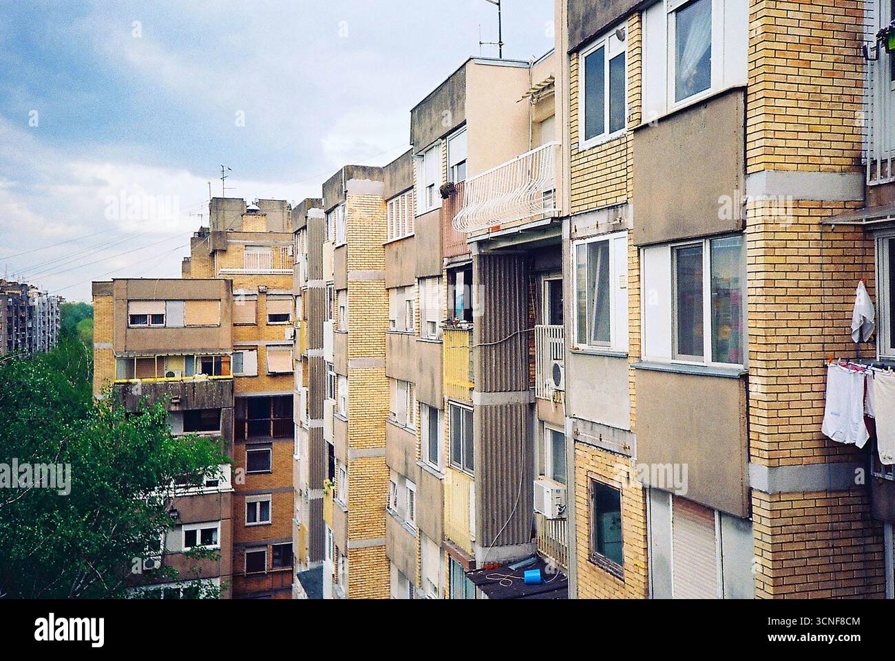 Foto analogica della lavanderia appesa ad asciugare su un balcone. Uno sguardo tranquillo sulla vita di tutti i giorni, incorniciato da luce, consistenza e quiete domestica. Foto Stock