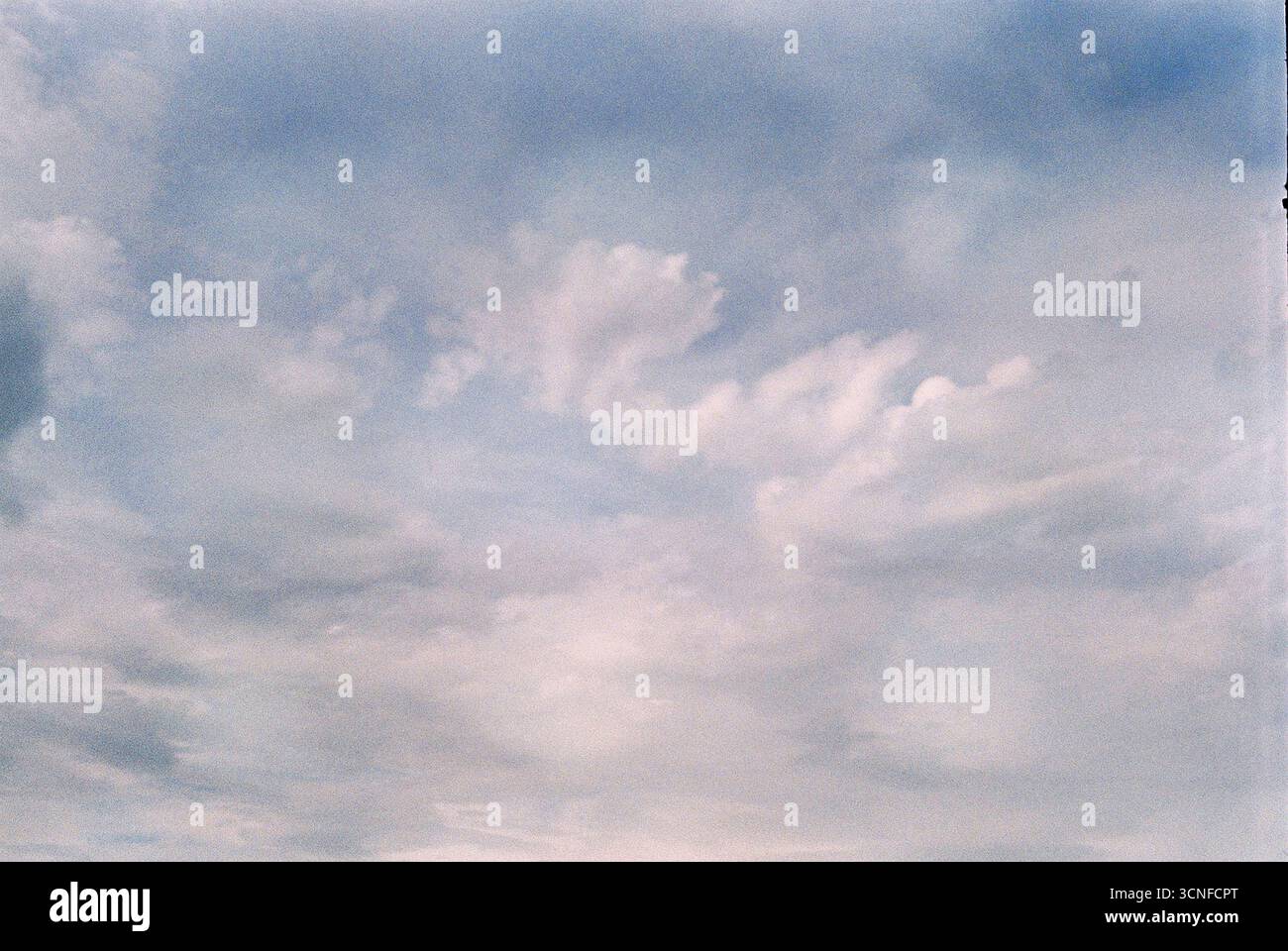 Fotografia analogica di nuvole catturate in modo poetico e astratto. Texture morbide, forme organiche e atmosfera emotiva in uno sguardo rivolto verso il cielo. Foto Stock