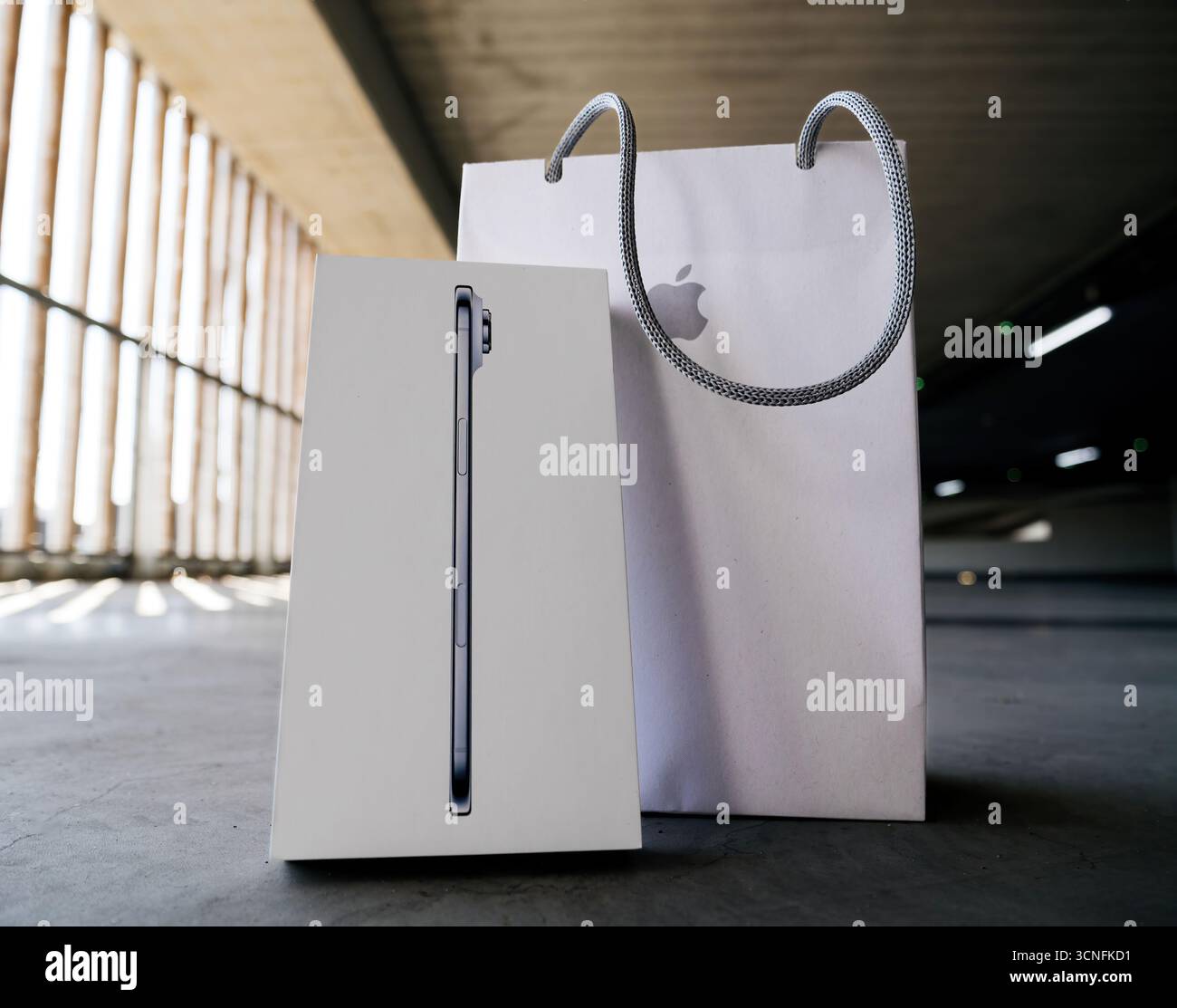 Parigi, Francia - 19 settembre 2025: Primo piano della nuova scatola per la vendita al dettaglio Apple iPhone Air posta accanto alla shopping bag ufficiale Apple Store bianca con logo all'interno del moder Foto Stock