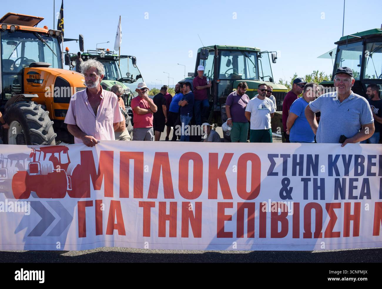 Karditsa, Tessaglia, Grecia. 18 settembre 2025. Le proteste degli agricoltori bloccano la National Highway E65 e tengono uno striscione che recita: “Blocco al governo per la nostra sopravvivenza” durante una manifestazione. I sindacati degli agricoltori hanno annunciato mobilitazioni in tutto il paese per l'aumento dei costi e anche per denunciare la frode OPEKEPE (Agenzia ellenica per i pagamenti agricoli e il controllo) delle sovvenzioni UE. Crediti: Dimitris Aspiotis/Alamy Live News Foto Stock