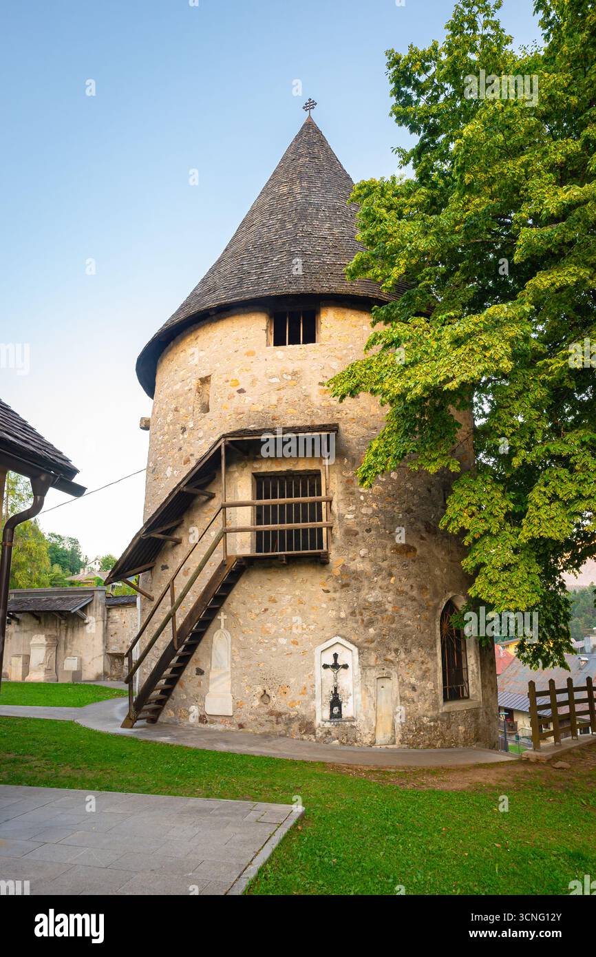 Storica torre in pietra con tetto conico, scala in legno e lussureggiante parco. Parte della chiesa fortificata dei Santi Pietro e Paolo. Foto Stock Storica torre in pietra con tetto conico, scala in legno e lussureggiante parco. Parte della chiesa fortificata dei Santi Pietro e Paolo. Foto Stock