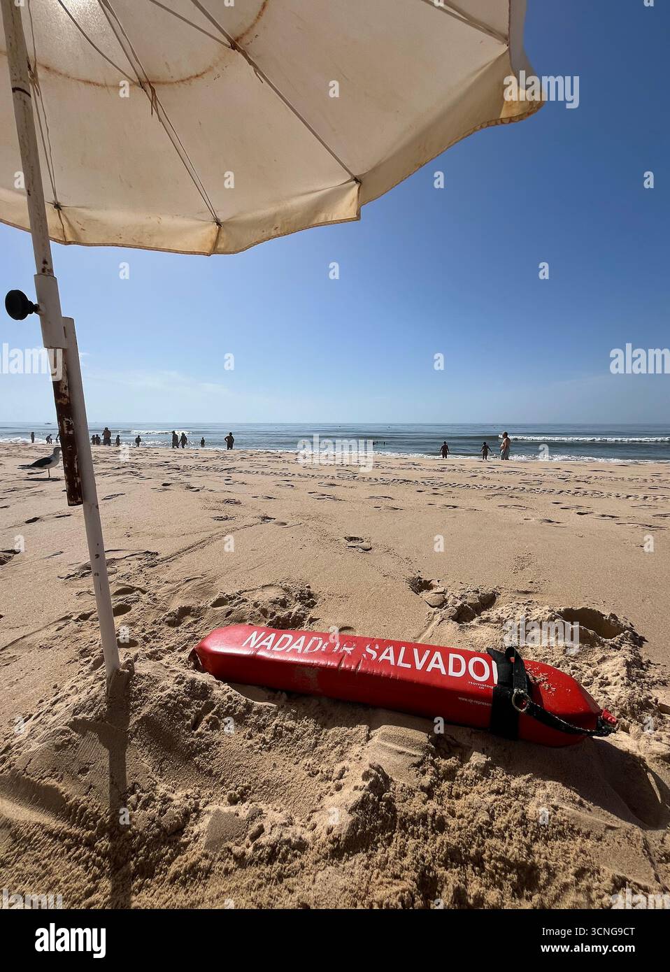 Attrezzatura bagnino sulla spiaggia sabbiosa di Monte Gordo in Algarve con persone che si godono la giornata di sole sull'oceano. - Immagine stock catturata con smartphone