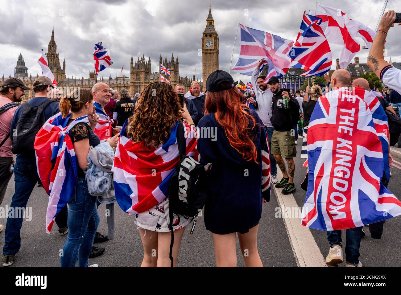 Le persone marciano sul ponte di Westminster sventolando Union Flags durante il Unite the Kingdom Rally organizzato dall'attivista Tommy Robinson, Londra, Regno Unito. Foto Stock