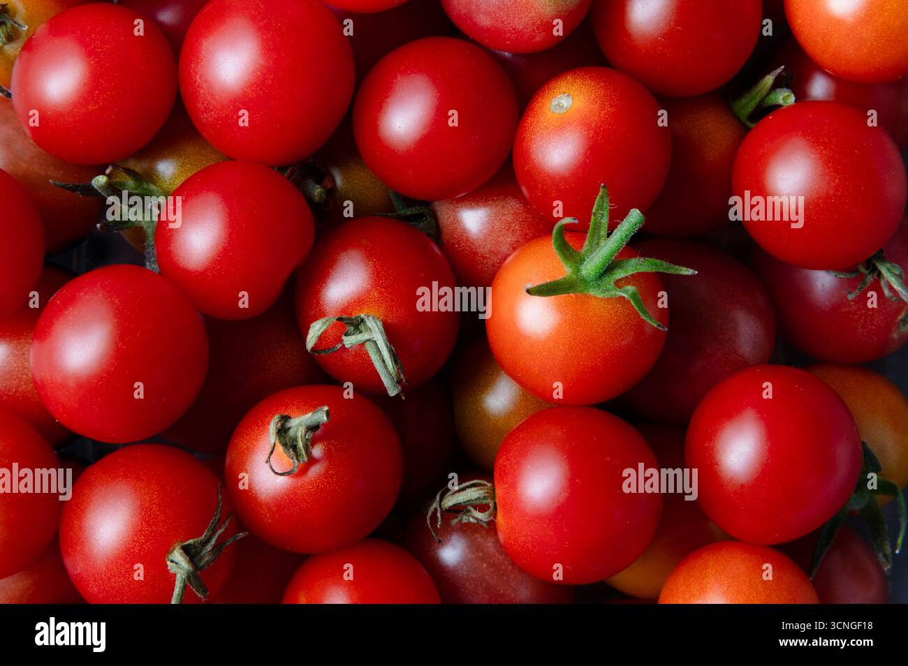 Pila di pomodori ciliegini rossi, full frame Foto Stock