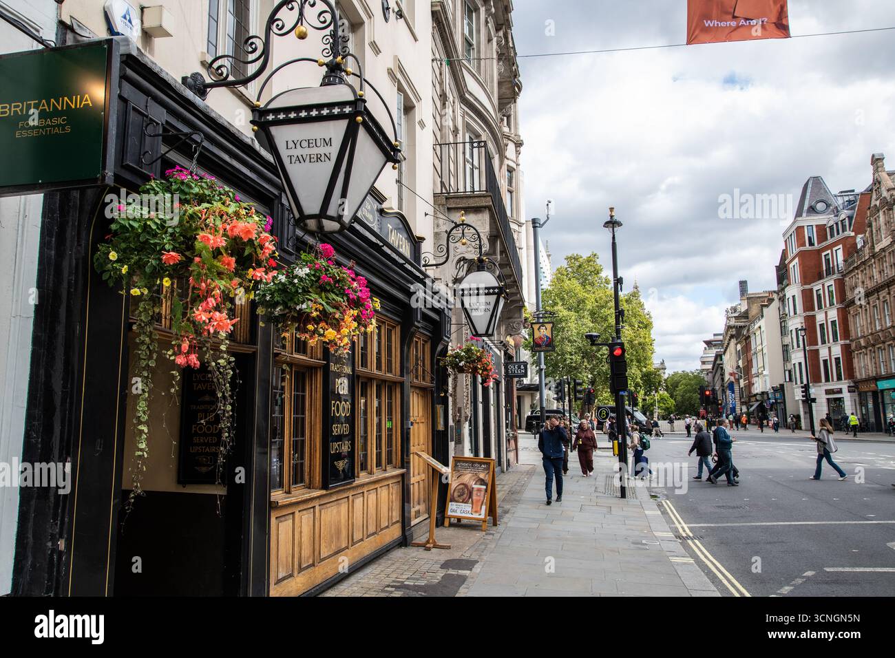 Affascinante esterno della storica taverna Lyceum nello Strand di Londra, adornato da vivaci cesti di fiori appesi. Perfetto per viaggi e architettura Foto Stock