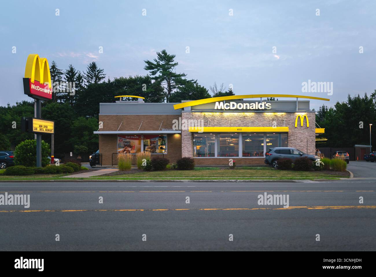 New Hartford, New York - 6 agosto 2025: Ampia vista serale del ristorante McDonald's, fondato nel 1940, è una delle più grandi catene di fast food del mondo, con molto altro ancora Foto Stock