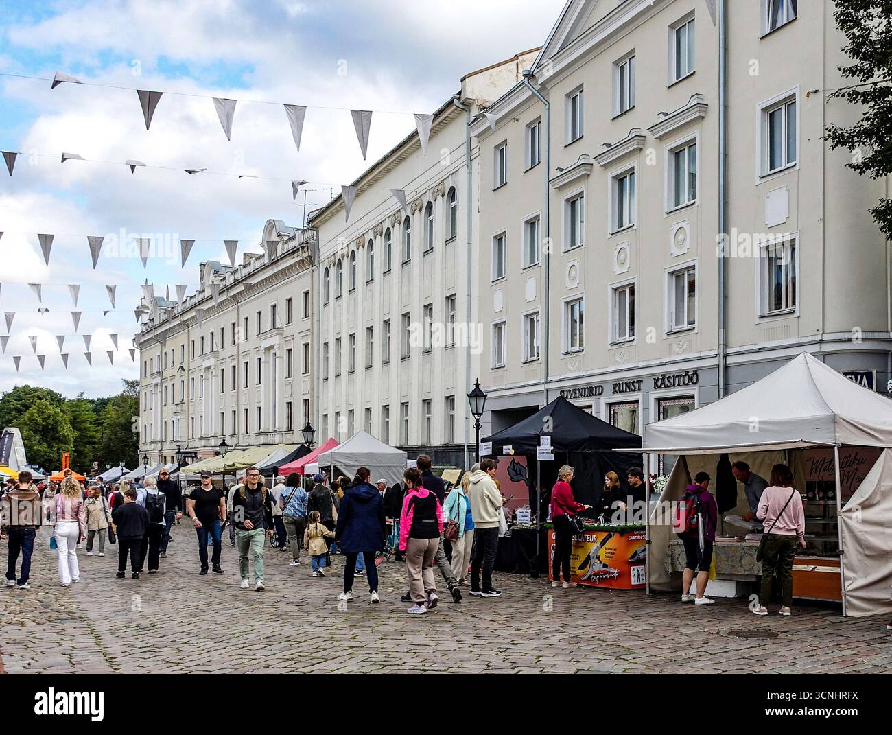 Mercato del fine settimana nella Piazza del Municipio di Tartu, in Estonia, con bancarelle, acquirenti e architettura storica che creano un'atmosfera culturale e sociale vivace Foto Stock