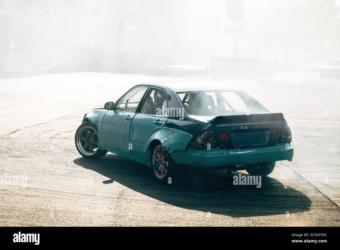 Auto sportive alla deriva su strada asfaltata, pneumatici che girano producendo fumo denso durante gli sport motoristici. Messa a fuoco selettiva. Foto Stock