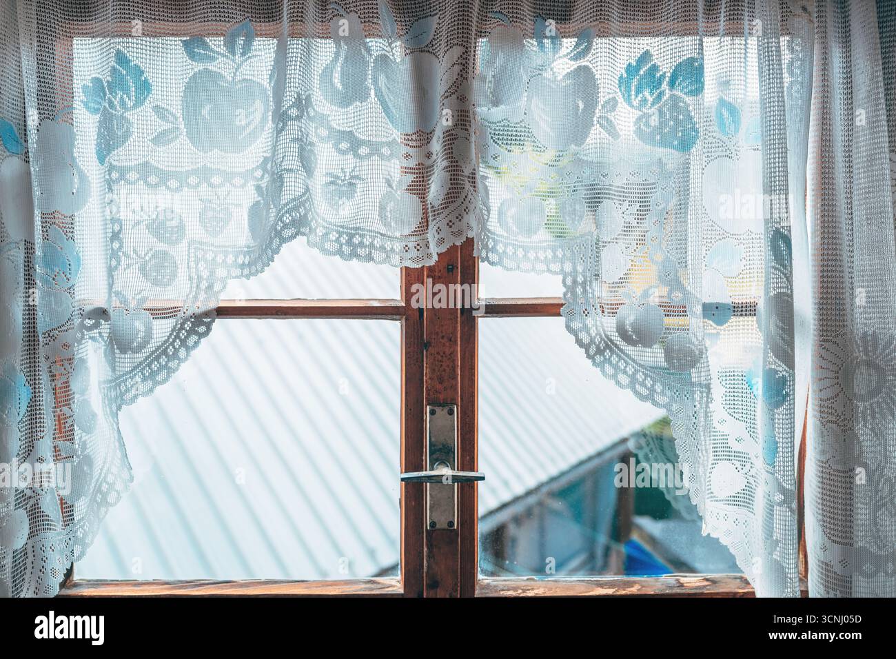 Vecchia tenda a uncinetto su una cornice in legno che simboleggia la tradizione, la nostalgia e l'accogliente eredità della vita rurale. Messa a fuoco selettiva. Foto Stock