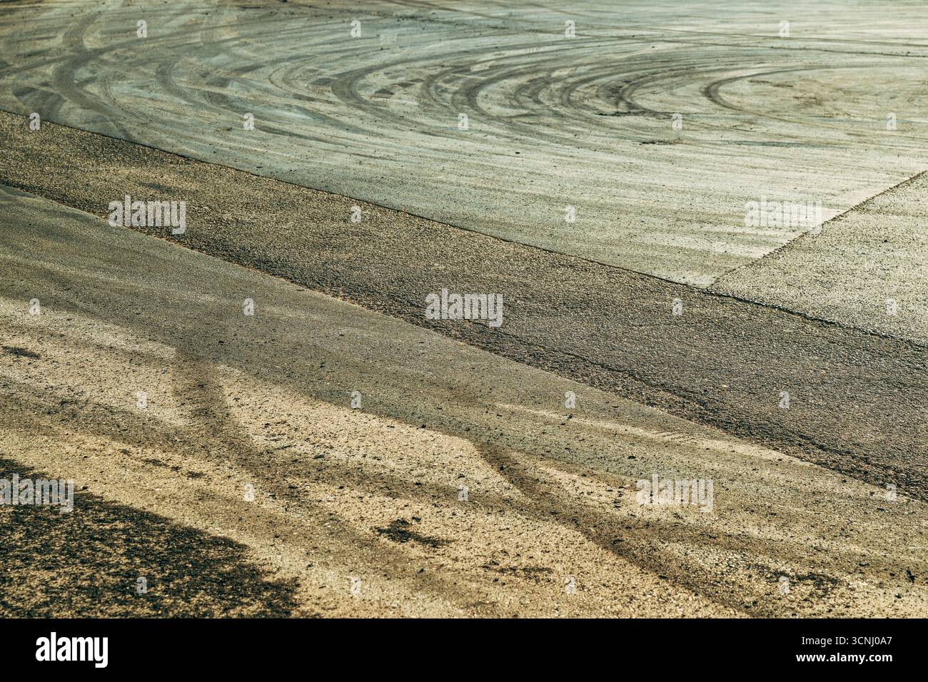 Linee in gomma bruciata incise sull'asfalto, tracce visive di adrenalina, energia e movimento dopo uno spettacolo di deriva dell'auto. Segni di slittamento e gomma bruciata lasciata accesa Foto Stock