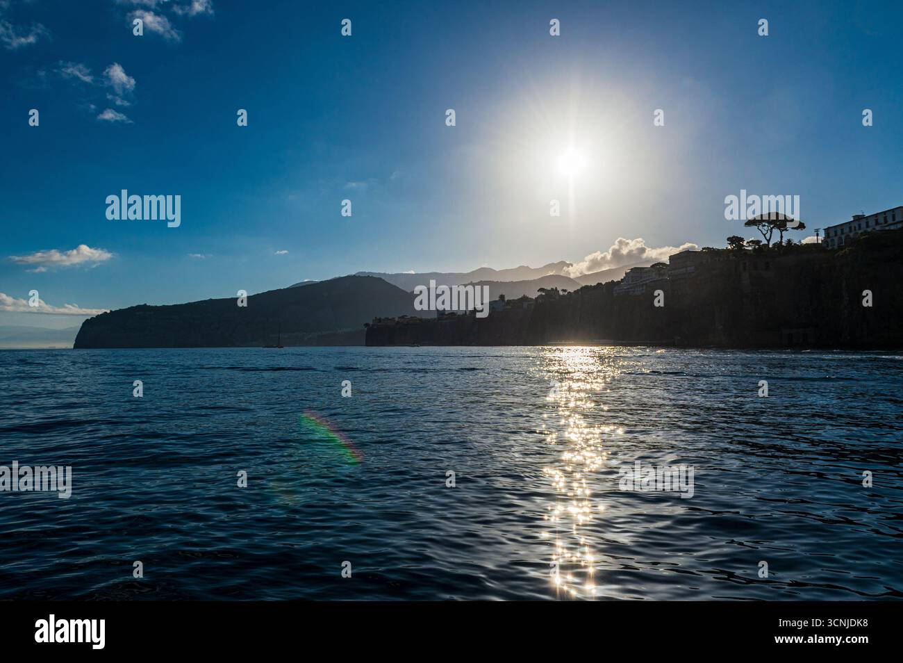 Vista delle colline della penisola sorrentina retroilluminate dal sole dal molo dei traghetti di Capri, in Italia Foto Stock