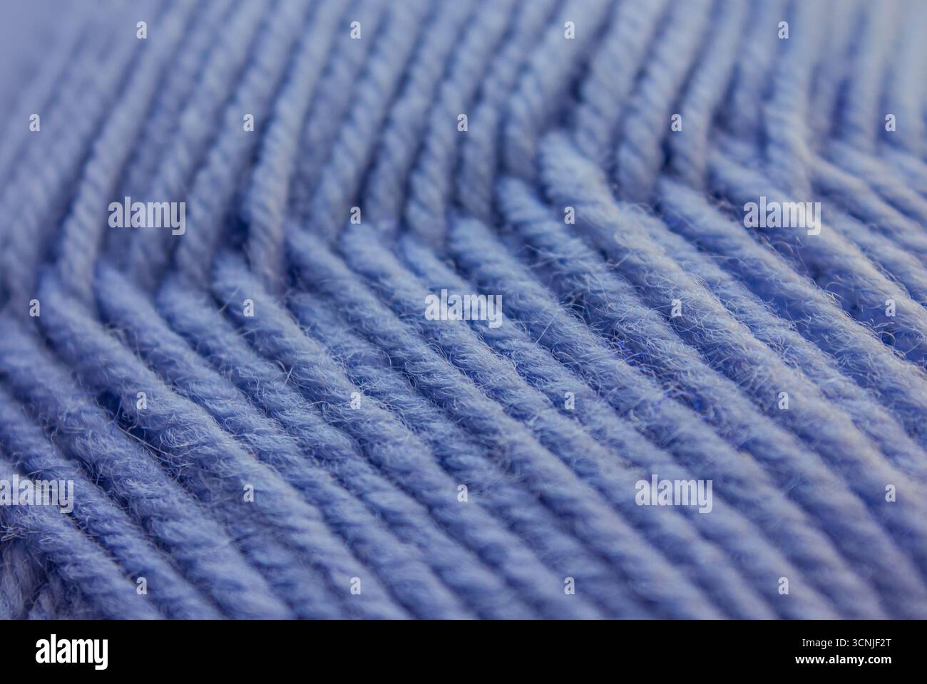 Primo piano, sfondo a maglia in lana blu. Sfondo astratto delle filettature Blue Yarn. Sfondo testurizzato in filato blu. Foto Stock