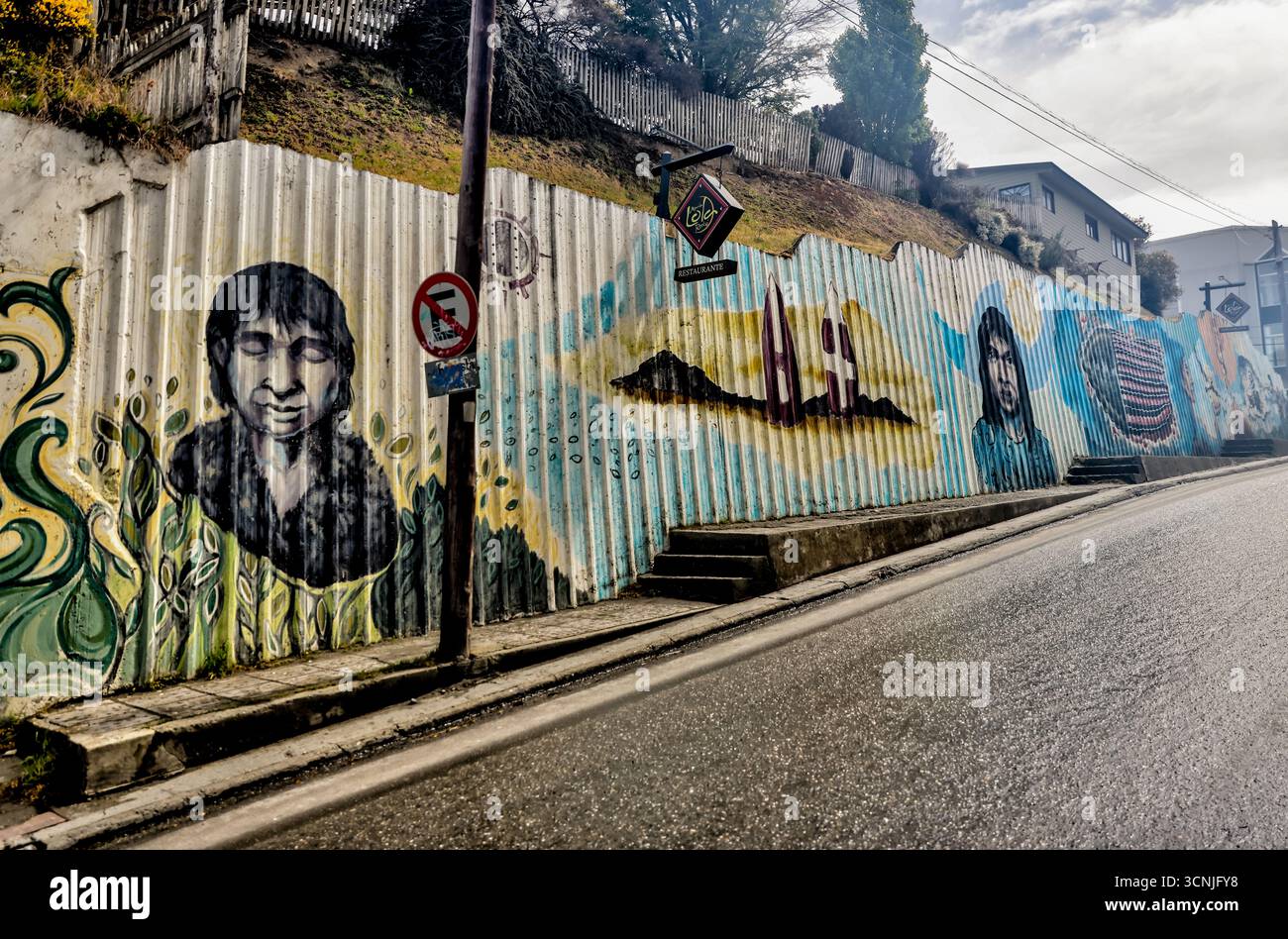 Colorato murale all'aperto lungo una strada residenziale a Ushuaia, che ritrae i popoli indigeni della Terra del fuoco, tra cui Yaghan e Selk'nam fi Foto Stock