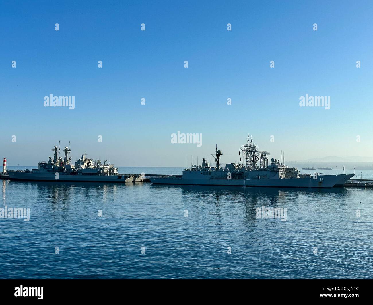 Le navi da guerra della Marina cilena attraccavano al largo della costa di Valparaíso nelle calme acque mattutine dell'Oceano Pacifico, stagliate contro un cielo azzurro Foto Stock