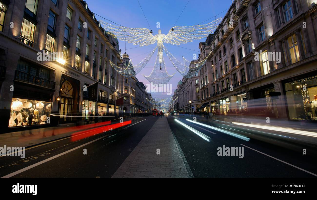 LONDRA, REGNO UNITO. 17 DICEMBRE 2016. Regent Street decorata con angeli natalizi all'ora blu, mentre i fari e le luci posteriori delle auto formano vivaci percorsi di luce. Foto Stock