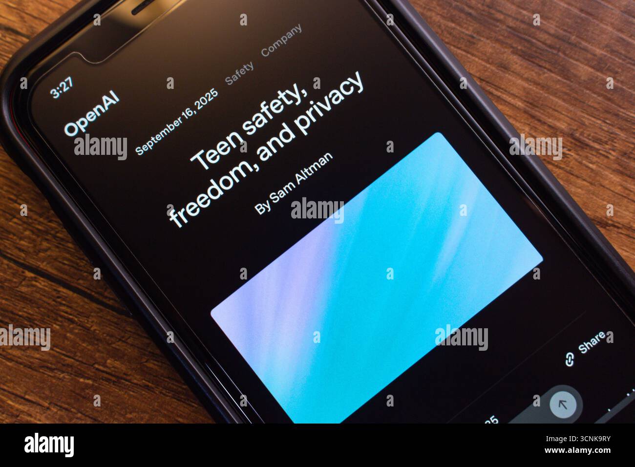 Primo piano dello schermo di uno smartphone che mostra un articolo OpenAI intitolato "sicurezza per i giovani, libertà e privacy" su una superficie in legno. Foto Stock