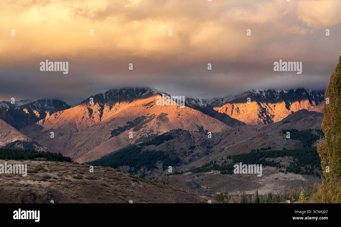 Sole che illumina le montagne su un tramonto nuvoloso, Patagonia Argentina Foto Stock
