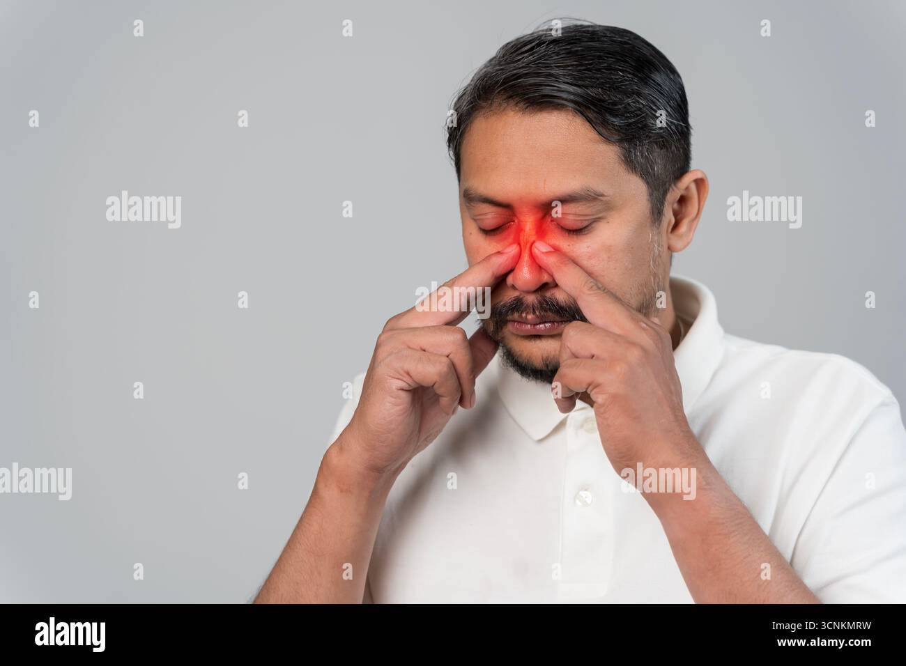 Primo piano uomo che preme naso con espressione dolorosa e rosso evidenziare, concetto di infezione sinusale, allergia, dolore nasale, problema di salute, assistenza sanitaria, med Foto Stock