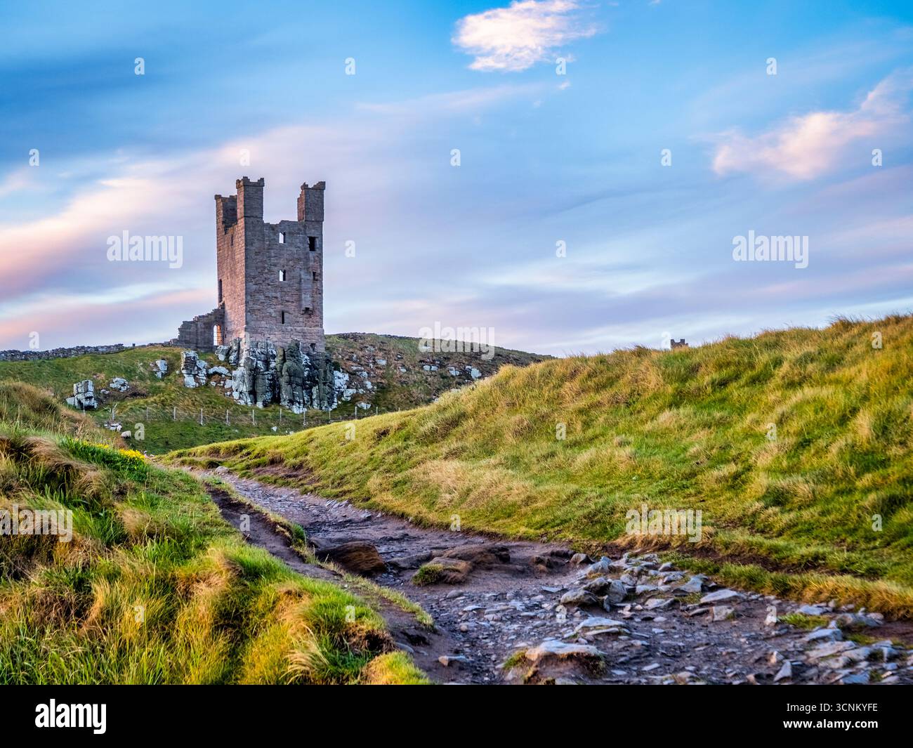 Castello di Dunstanburgh, Northumberland, Regno Unito - la mattina presto in primavera. Foto Stock