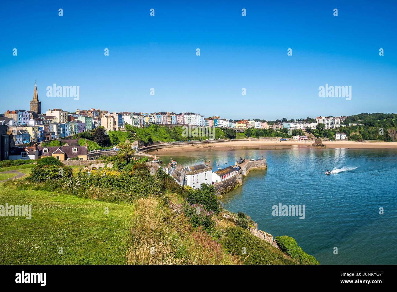 Vista della città di Tenby e di North Beach dal basso del castello di Tenby, nel Pembrokeshire, Galles del Sud. Bella giornata con cielo azzurro. Foto Stock