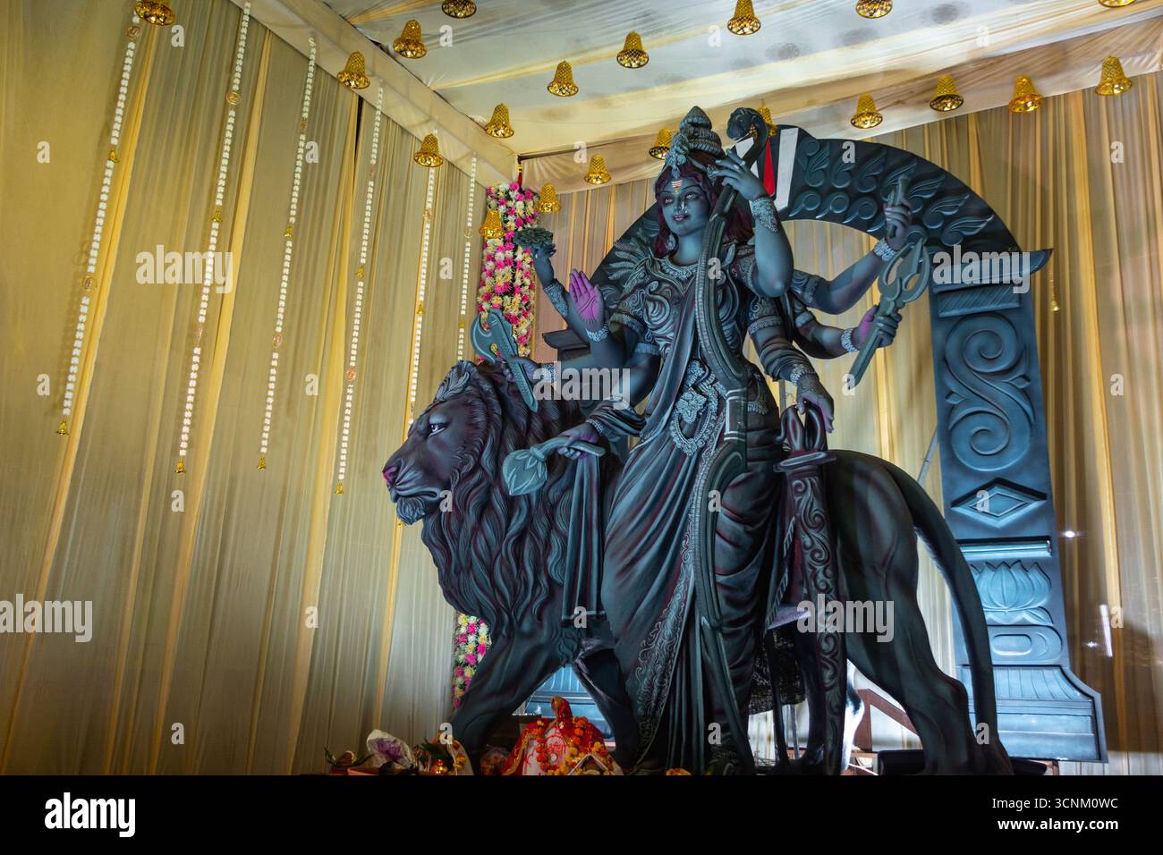 Un bellissimo idolo della dea Durga con diverse braccia che reggono varie armi, seduto su un maestoso leone, esposto durante il festival Navratri. Foto Stock
