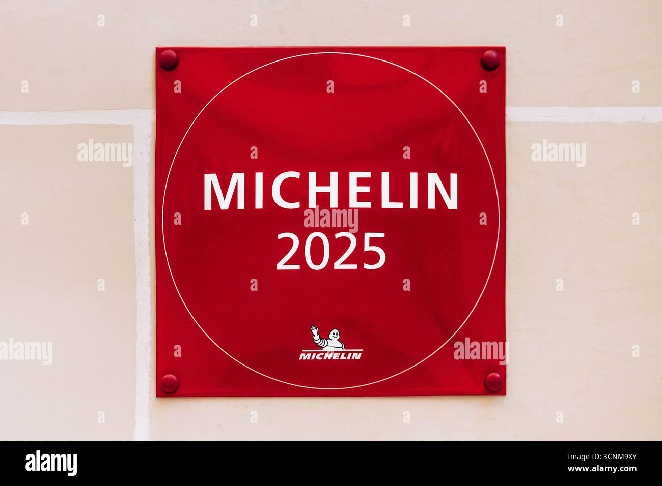 La Valletta, Malta – 11 aprile 2025: Targa Michelin 2025 rossa montata su una parete bianca, a simboleggiare il prestigioso riconoscimento per l'eccellenza culinaria Foto Stock